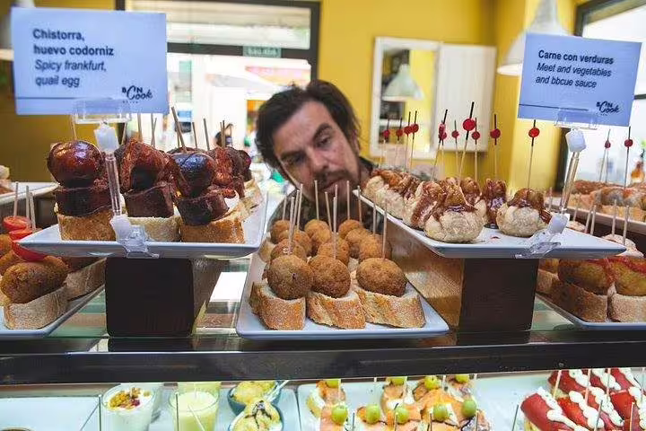 A variety of delicious Spanish tapas on display in a vibrant Barcelona market during a food and drink tasting tour.