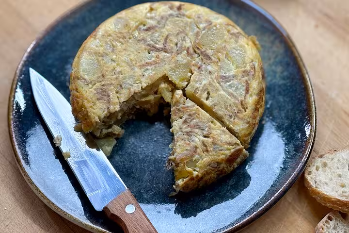 Traditional Spanish tortilla on a rustic plate, showcasing authentic culinary experiences in a Barcelona tapas class.