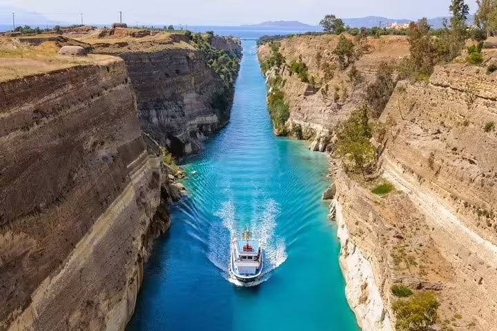Cruise boat in the Corinth Canal’s turquoise waters, scenic stop on Sparta full day tour from Athens
