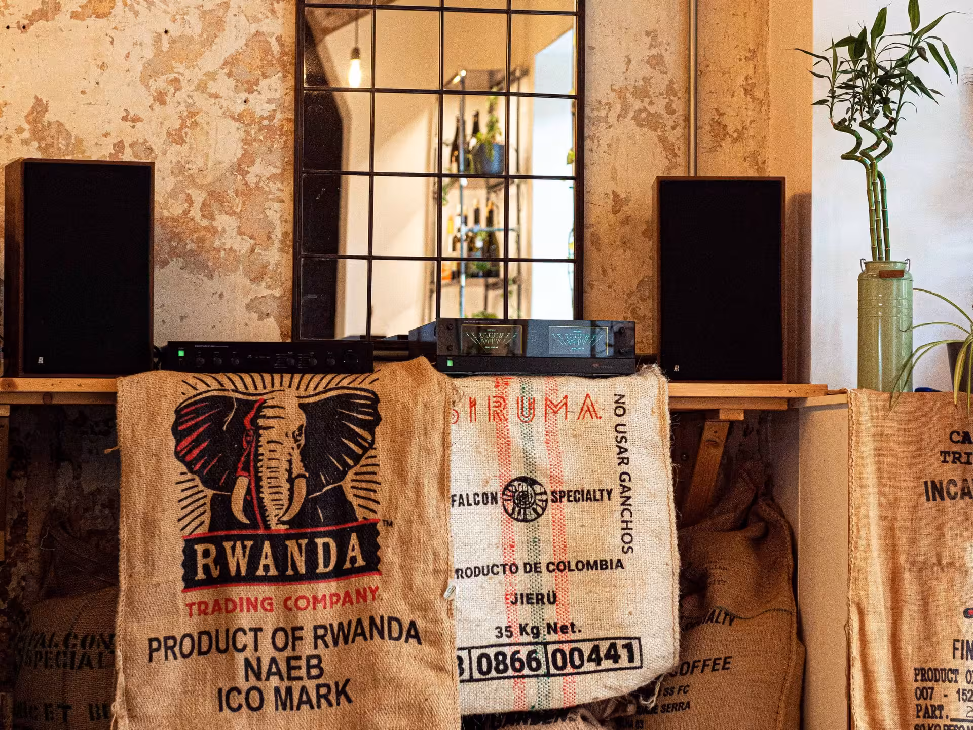 Rustic coffee shop corner with burlap coffee sacks from Rwanda and Colombia, featuring decor for a Rome tasting experience.