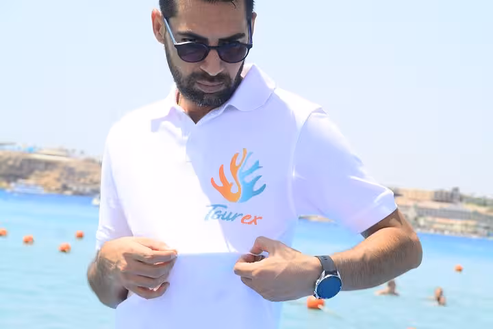 Tour guide in sunglasses by Sharm El Sheikh beach, ready for a 2-hour speed boat trip on the Red Sea