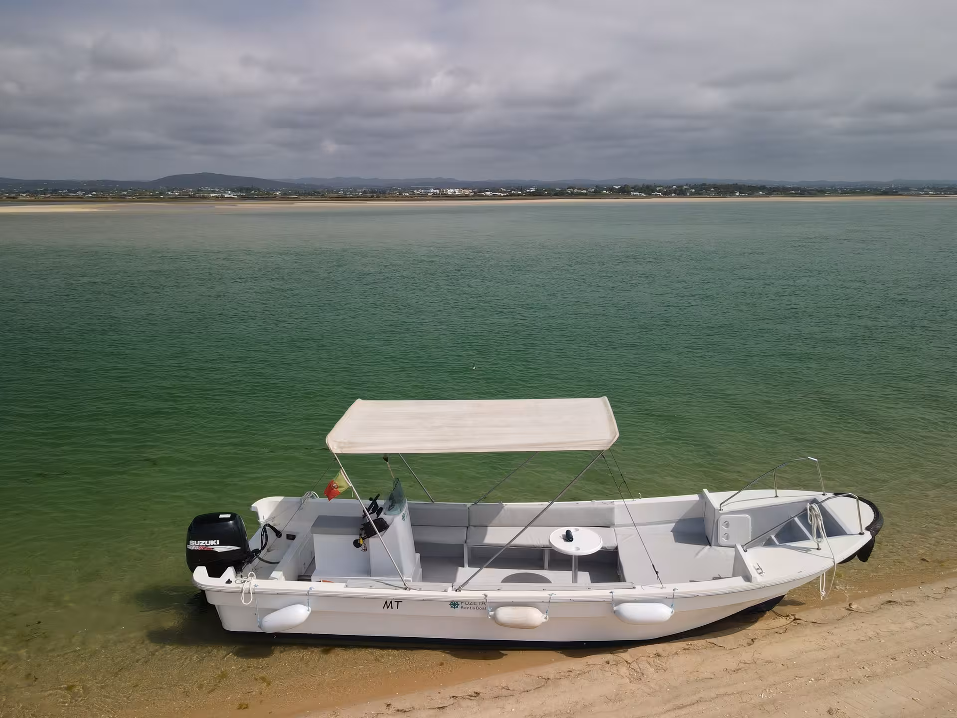 Rent-a-Boat Speed Boat Zurb moored at calm lagoon beach in Zurb, Algarve, ideal for family boat hire