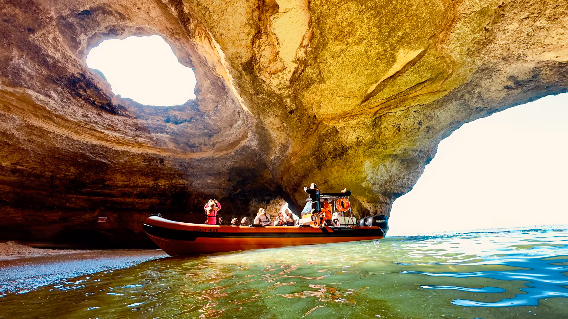 Speed boat with tourists exploring the stunning Benagil Cave sea hole in Algarve Portugal on a guided tour