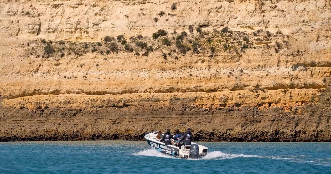 Speedboat cruising past golden Algarve cliffs on a private Benagil 1.5-hour cave tour along Portugal’s coast