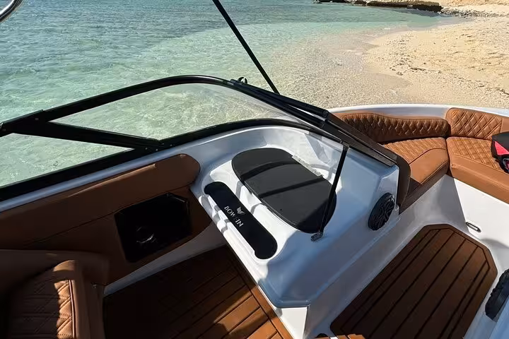 Speedboat cockpit and seating by turquoise shore on private Ozirea Island snorkeling tour from Hurghada