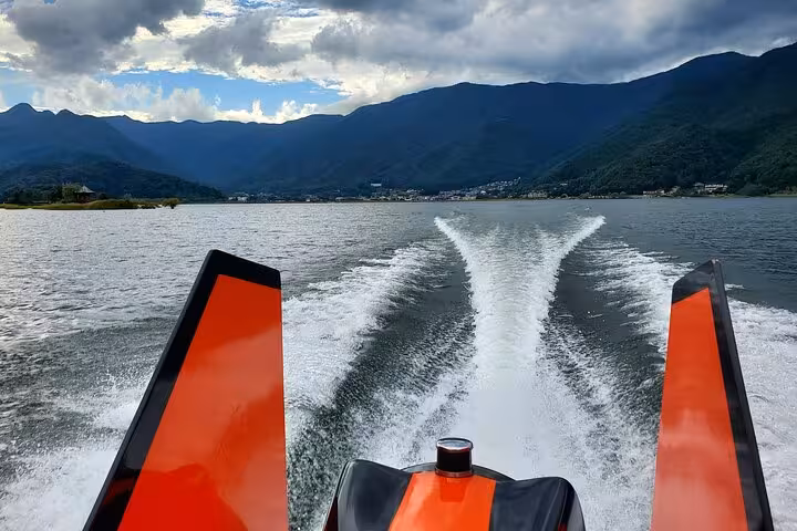 Speedboat creating waves on Lake Kawaguchi, offering thrilling experiences on Tokyo to Mt. Fuji customizable private tour.