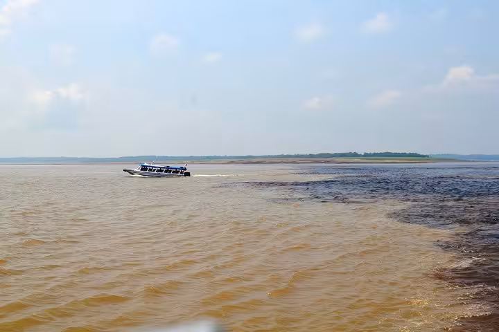 Speedboat crossing the Meeting of the Waters near Manaus where Rio Negro and Solimoes rivers meet