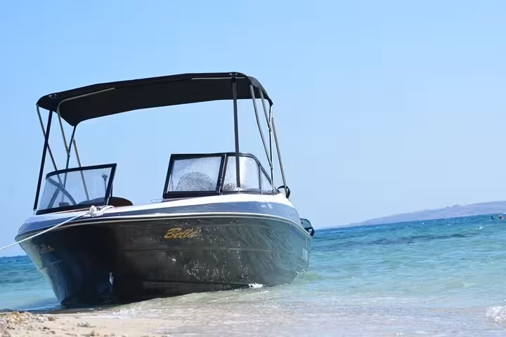 Speedboat moored at sandy shore before Ozirea Island snorkeling trip from Hurghada on the Red Sea