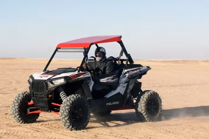 Spider car buggy driving across Marsa Alam desert sands, thrilling off-road adventure with camel ride add-on