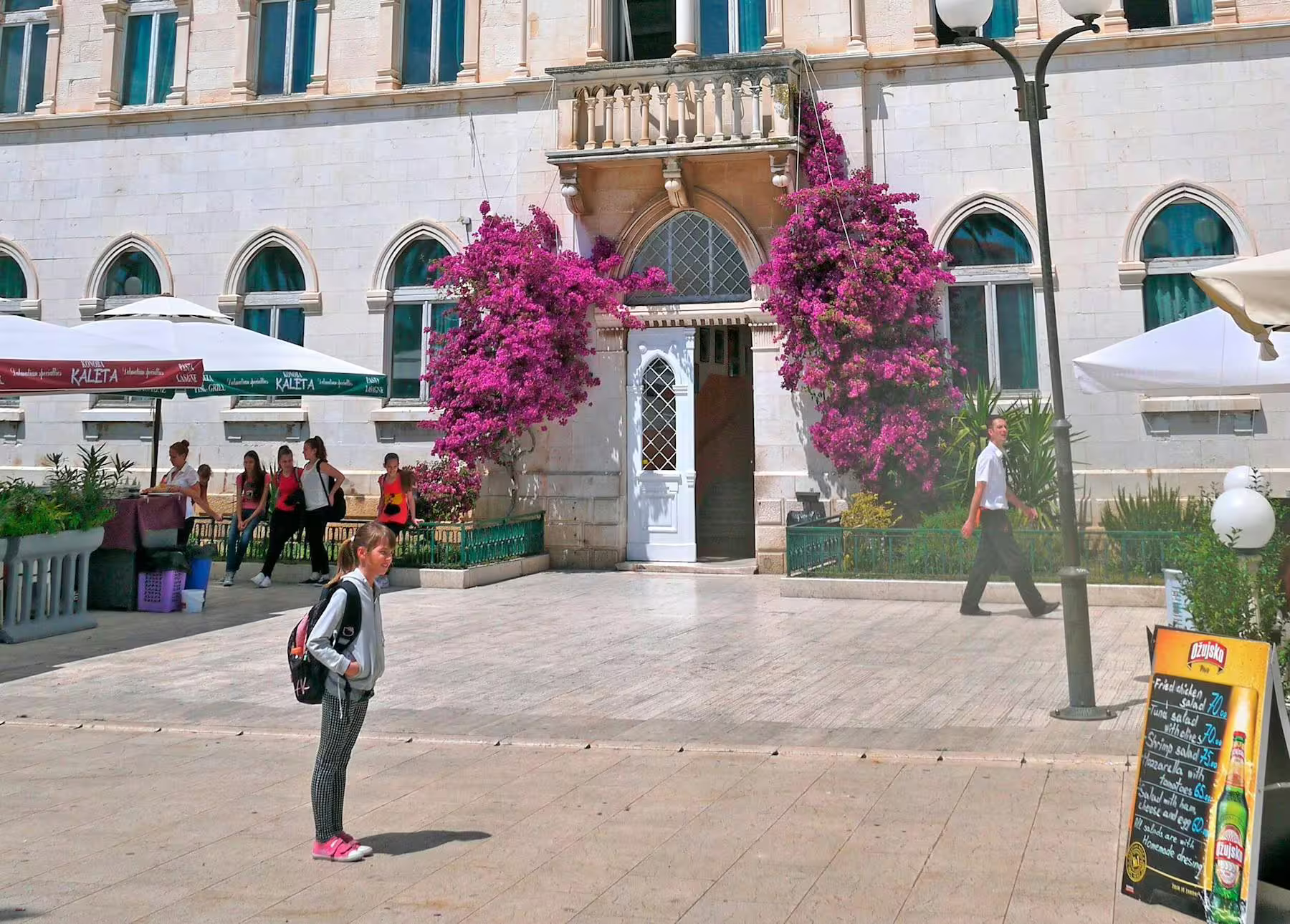 Split city center square with bougainvillea and historic facade, a highlight on Makarska Riviera day trip
