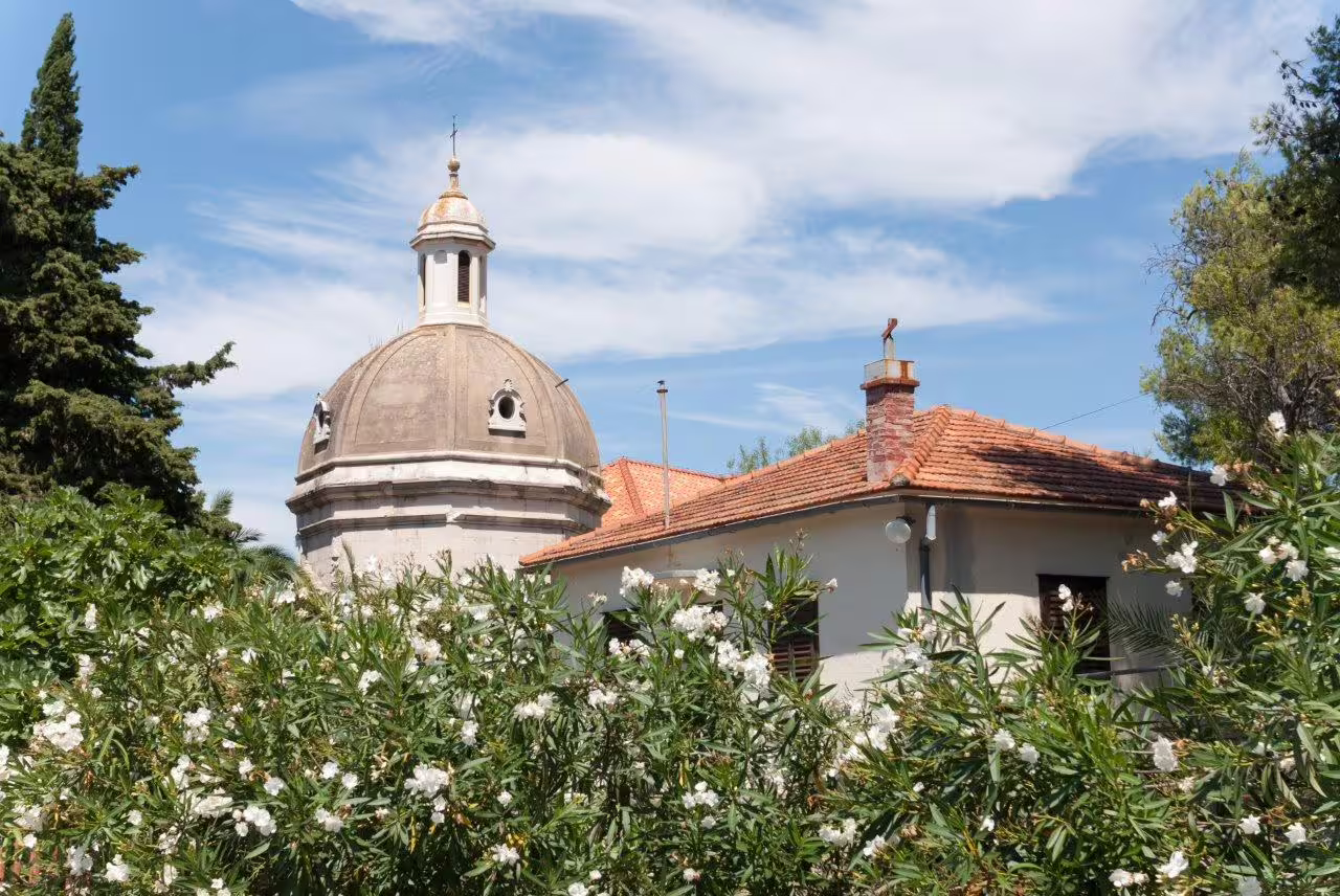 Dome church and terracotta rooftops amid Mediterranean gardens in Split, Croatia on a 3-day private tour
