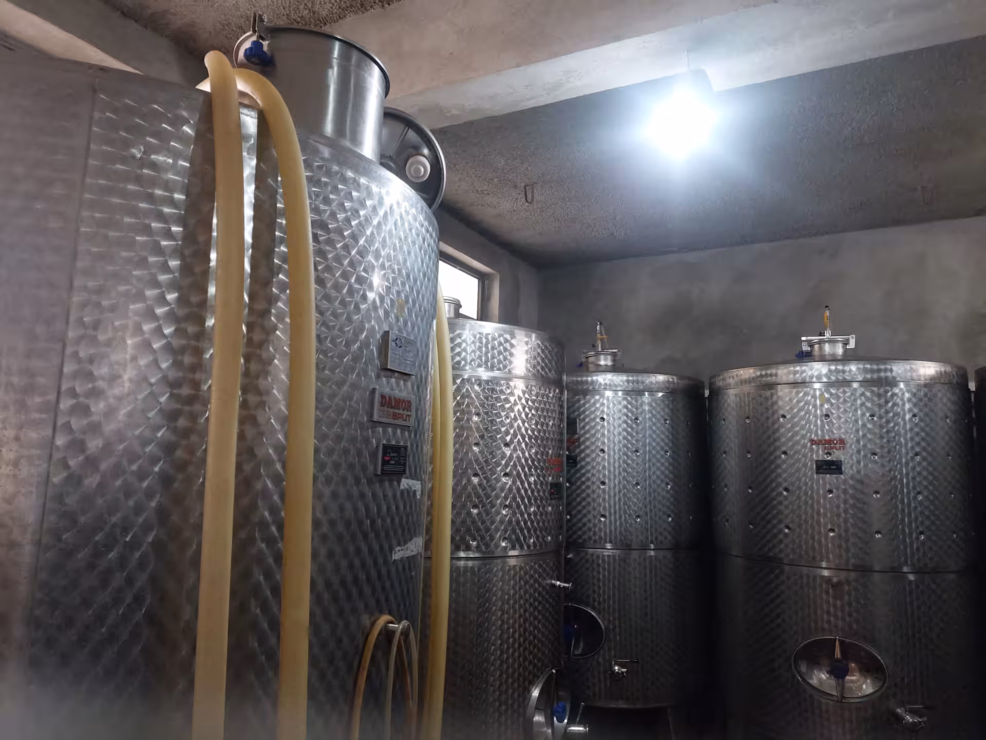 Modern winery cellar with stainless steel vats and hoses, part of Split hidden gems Imotski Lakes wine tasting