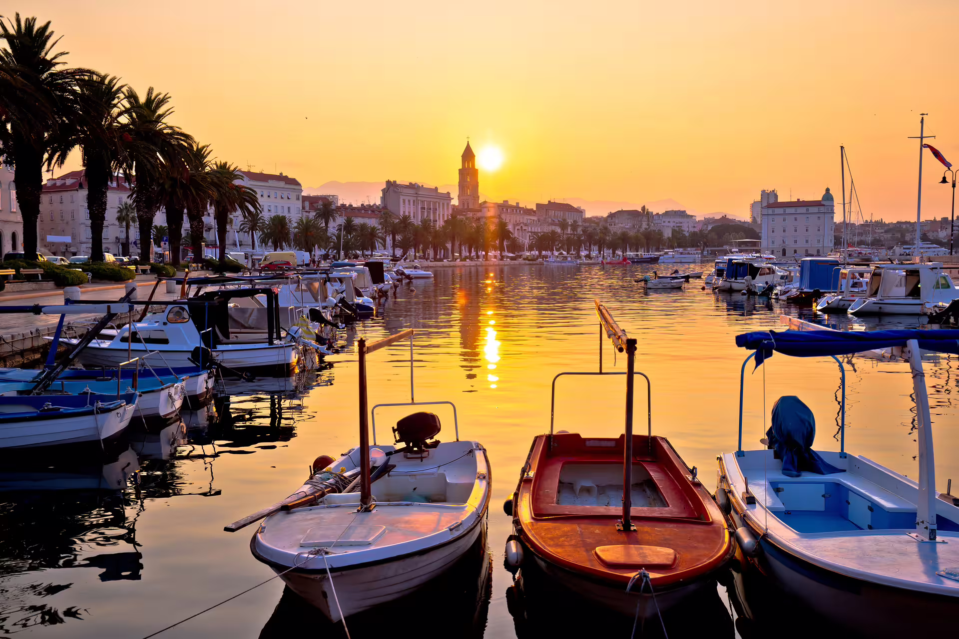 Split Riva waterfront at sunset with boats and palm trees, scenic stop on Split in 1 day walking tour audioguide