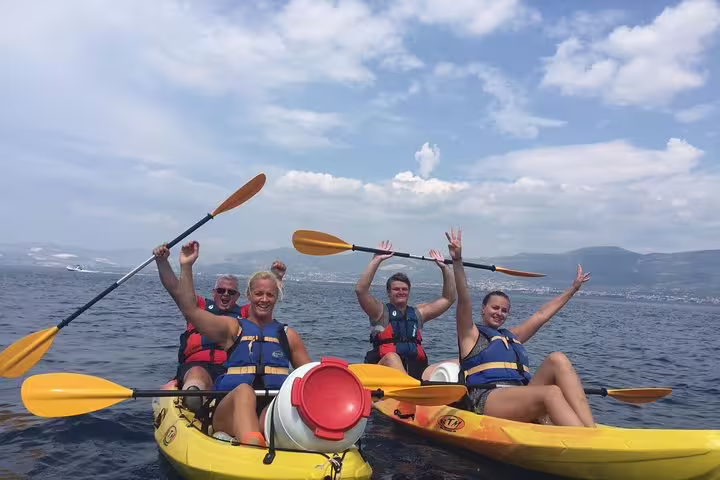 Happy guests on Split sea kayaking and snorkeling tour, paddling tandem kayaks on the Adriatic Sea