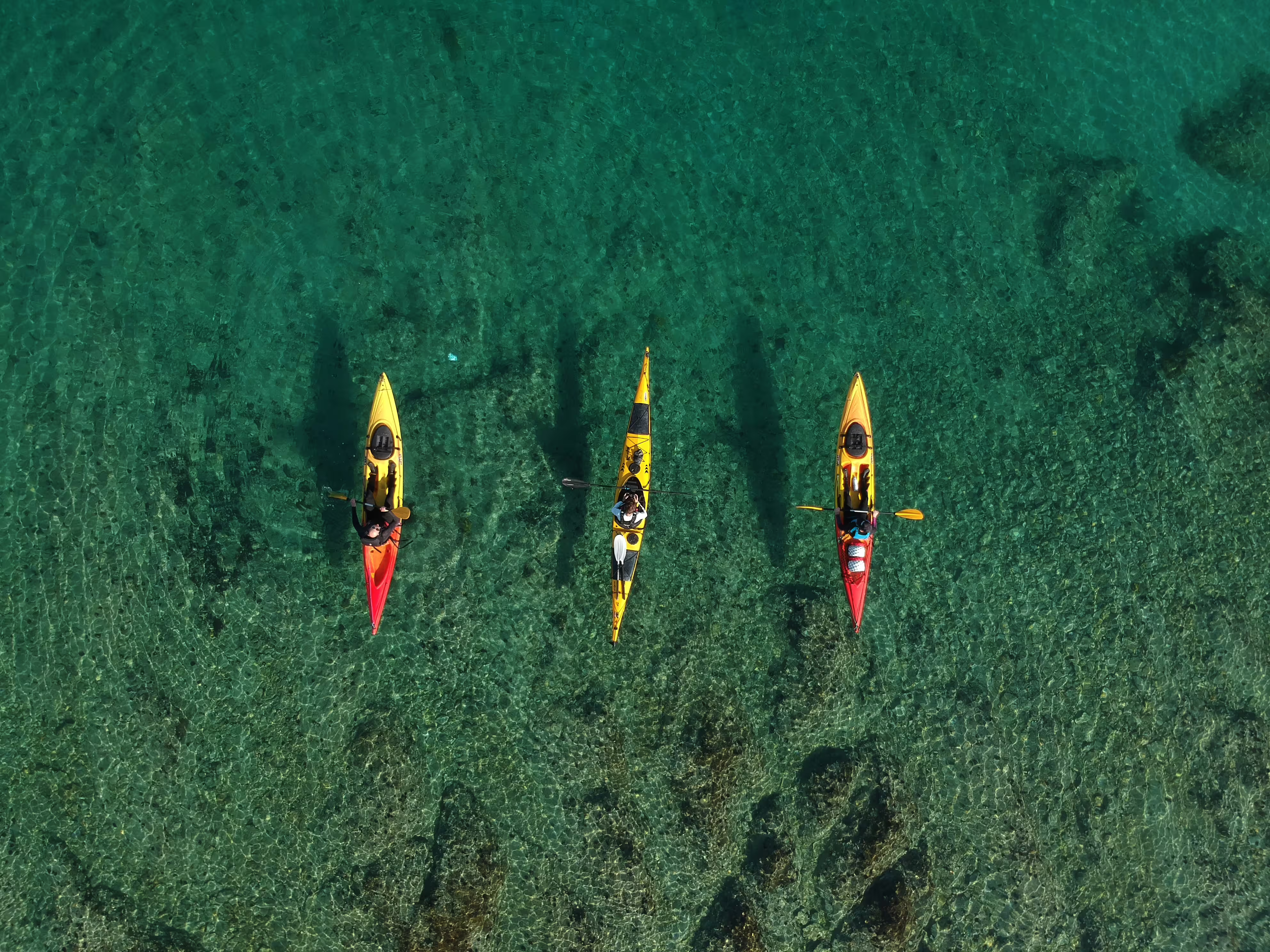 Aerial view of sea kayaks over crystal-clear Adriatic water on a Split sea kayaking and snorkeling tour