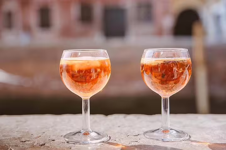 Two spritz cocktails on a canal-side table in Cannaregio, perfect for relaxing after exploring the Venetian district.