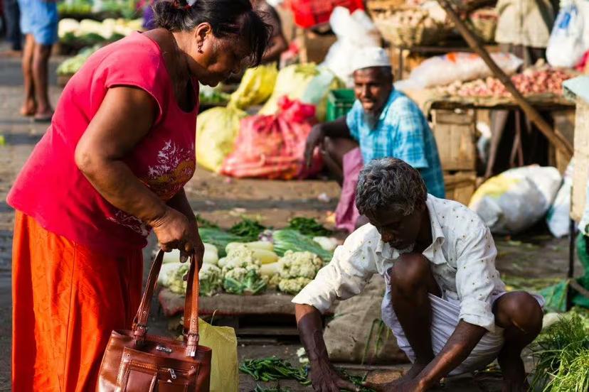 Local vendors at a bustling Sri Lankan market offering fresh produce, capturing the vibrant culture and daily life.