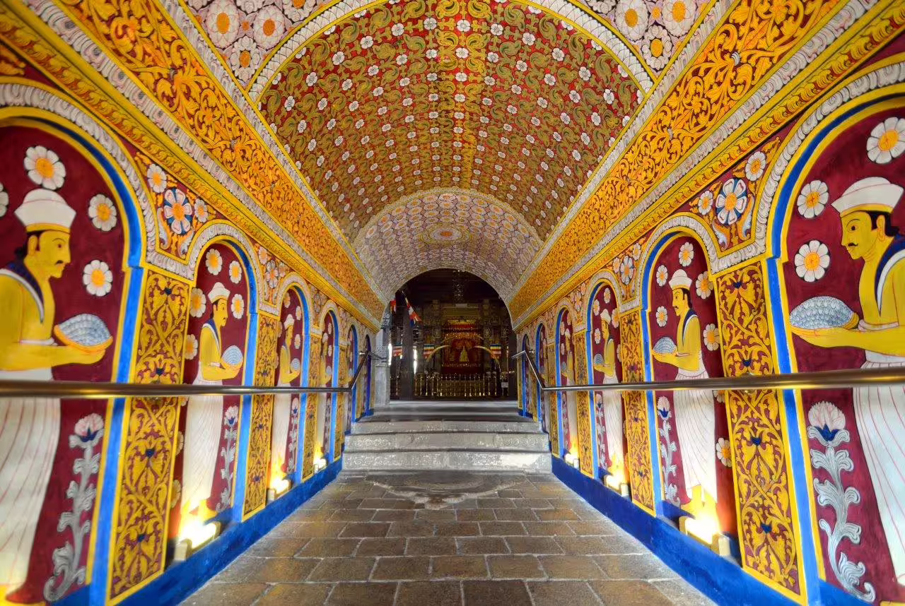 Vibrant interior of a Sri Lankan temple corridor adorned with intricate murals, featured on a private exclusive tea tour.