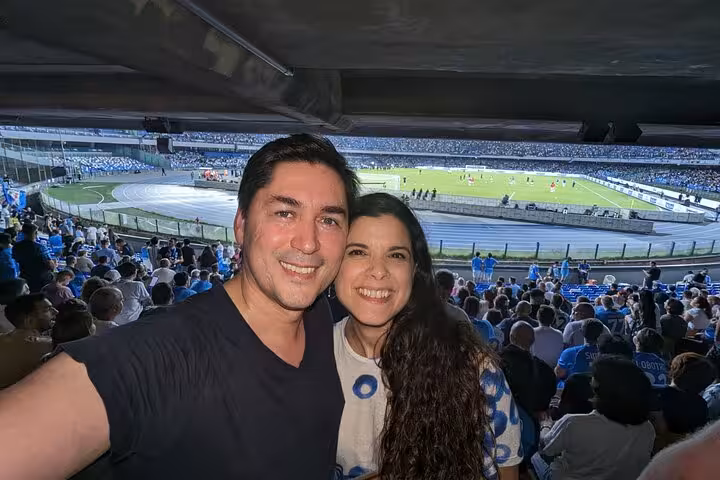 Fans take a selfie inside Diego Armando Maradona Stadium during an SSC Napoli match with local host