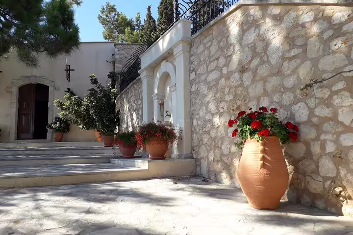 Charming courtyard of St. Irini Monastery with terracotta pots and vibrant flowers in Rethymno, Crete.