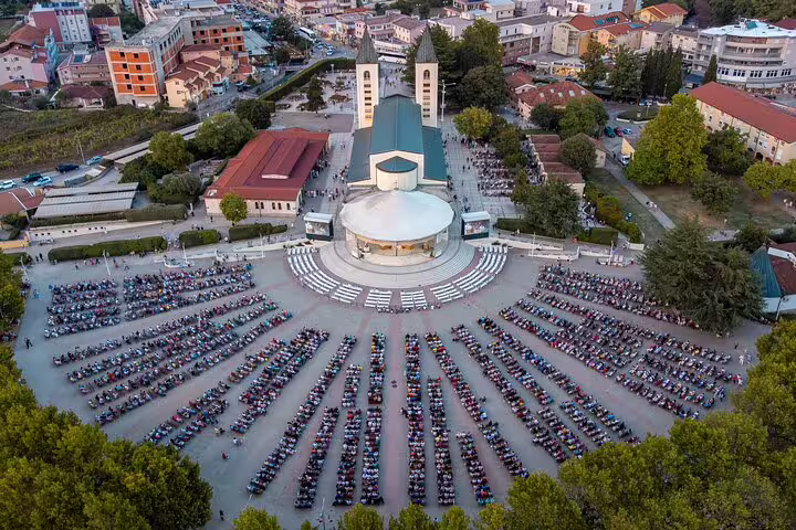 Aerial view of St. James Church in Medjugorje with a large gathering, part of a private full-day tour from Dubrovnik to Mostar and Medjugorje.