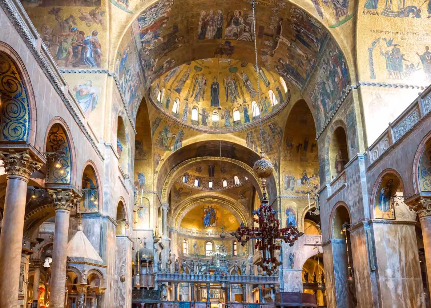 Stunning interior view of St. Mark's Basilica featuring golden mosaics and arches, key sights on Venice tours.