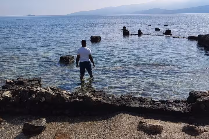 Visitor wading by ancient Corinth harbor ruins on St Paul’s Footsteps tour, Letters to the Corinthians 6-hour