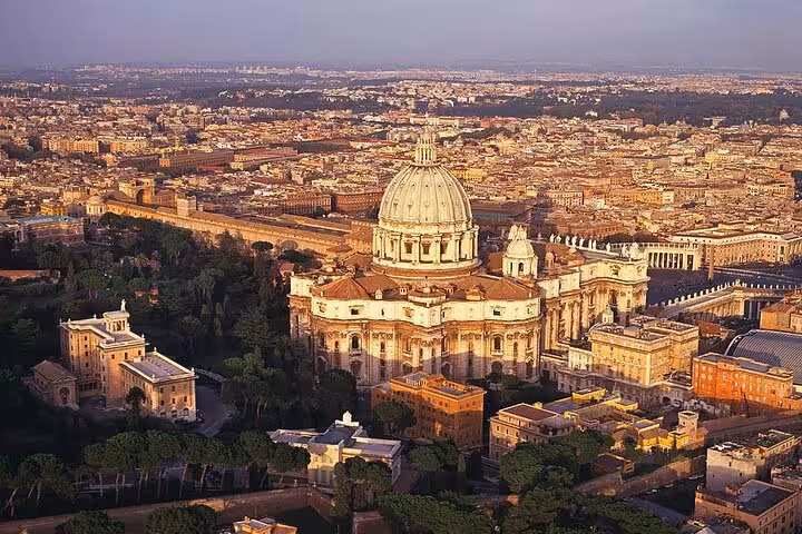 Aerial view of St. Peter's Basilica in Vatican City, highlighting its iconic dome and surrounding architecture.