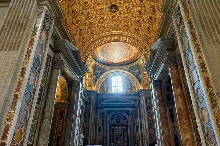 Grand interior view of St. Peter's Basilica with ornate columns and dome, enhancing Vatican tour experience.
