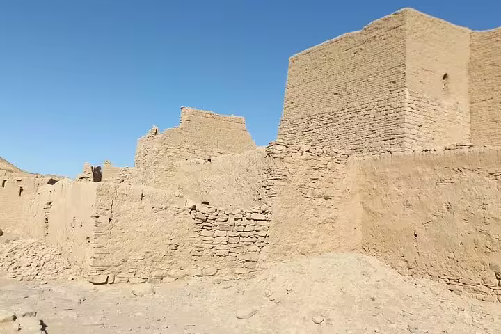Sunlit mud-brick walls and fort-like towers of St. Simeon Monastery, Aswan, Egypt cultural tour