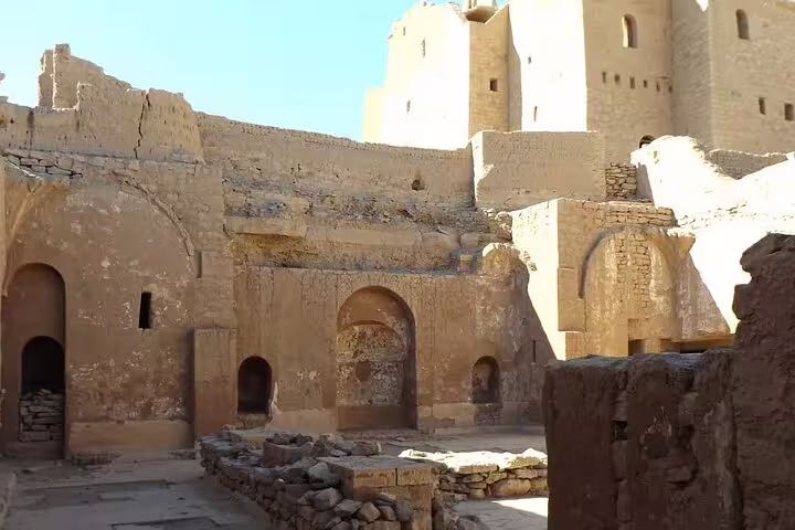 Sunlit courtyard with arched doorways inside St. Simeon Monastery, Aswan, on Nubian desert monastery tour