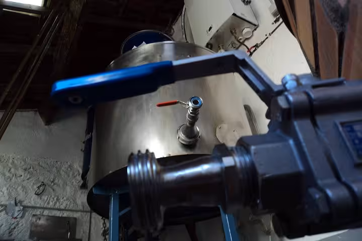 Stainless steel brewery tank and valve during local brewery tour, showcasing craft beer brewing process