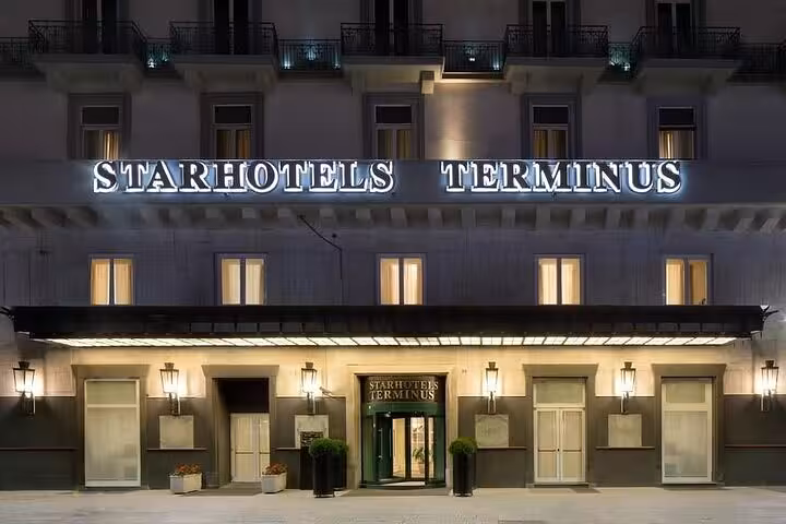 Starhotels Terminus exterior at night, a convenient stay option for travelers joining the Amalfi Coast boat tour from Naples.