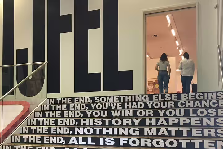 Stedelijk Museum Amsterdam entrance stairs with bold text mural, modern art museum visit on guided tour