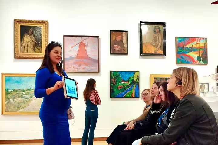 Guide presenting contemporary paintings inside Stedelijk Museum Amsterdam, small-group modern art tour talk