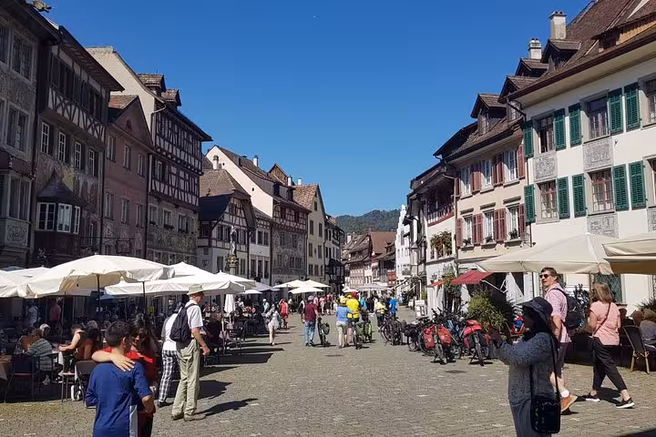 Charming street scene in Stein am Rhein with half-timbered houses and lively outdoor cafes, ideal for a private tour.