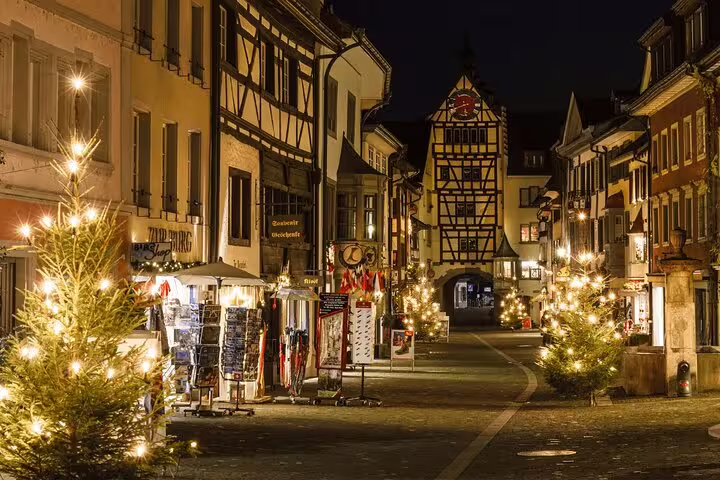 Charming night view of Stein am Rhein's illuminated medieval buildings and festive decorations on a Zurich day trip.
