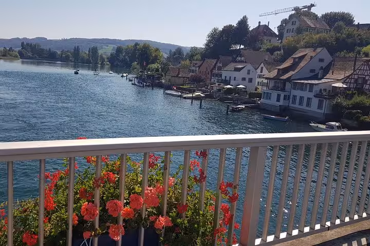 Charming riverside view from a bridge in Stein am Rhein, adorned with vibrant flowers and historic architecture.
