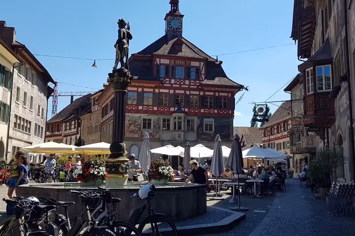 Historic fountain and vibrant cafes in Stein am Rhein's picturesque square, perfect for a Rhine Falls private tour.
