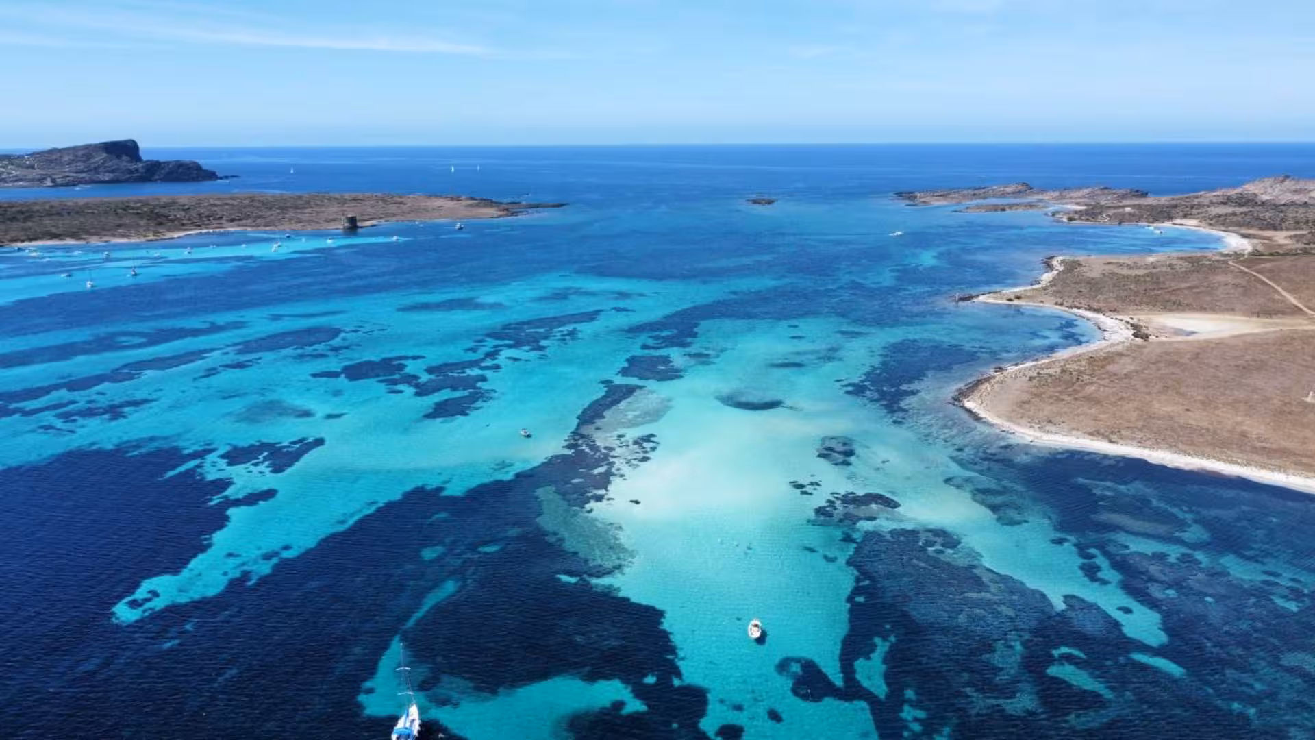 Panoramic view of vibrant blue waters and distant islands on the Stintino to Asinara boat trip with aperitif.