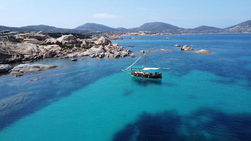 Sailboat anchored in the serene blue waters of Asinara, offering stunning views on a Stintino sailing tour.