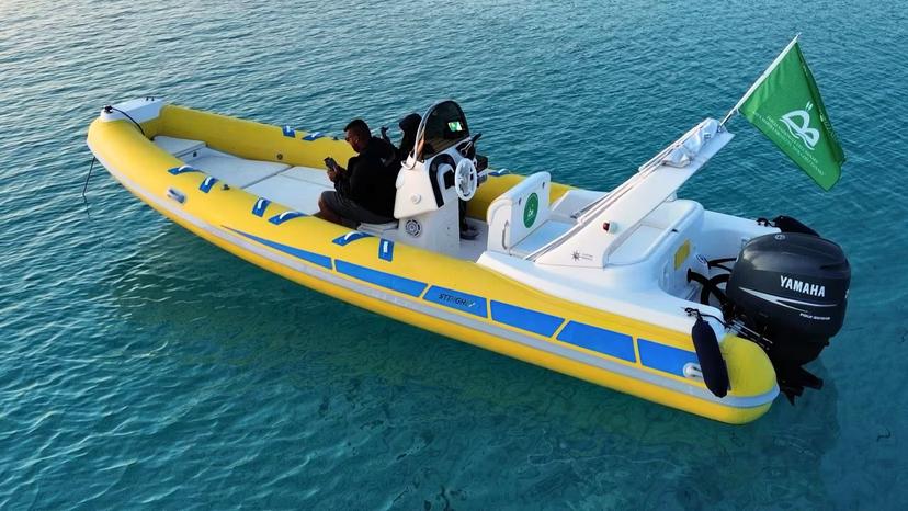 A vibrant yellow dinghy floats on clear blue waters, ideal for a Stintino two-hour sunrise or sunset tour.