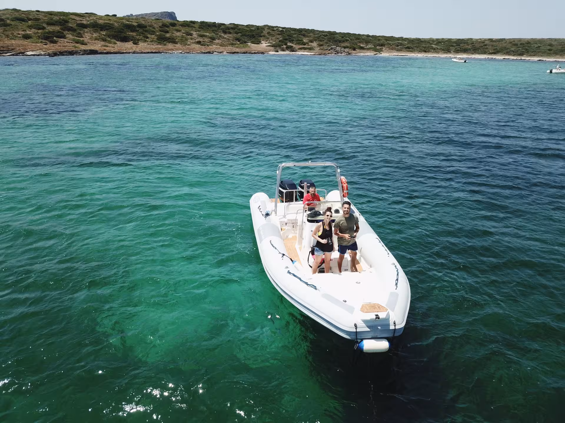 Tourists enjoy a RIB boat ride on the emerald waters of Asinara Gulf, surrounded by lush coastal scenery.