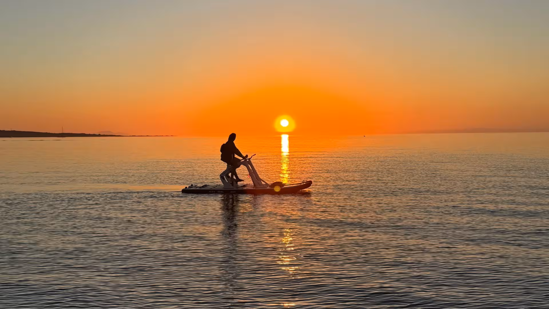 Solo rider on a water bike against a breathtaking sunset backdrop in La Pelosa, Stintino, creating a serene scene.