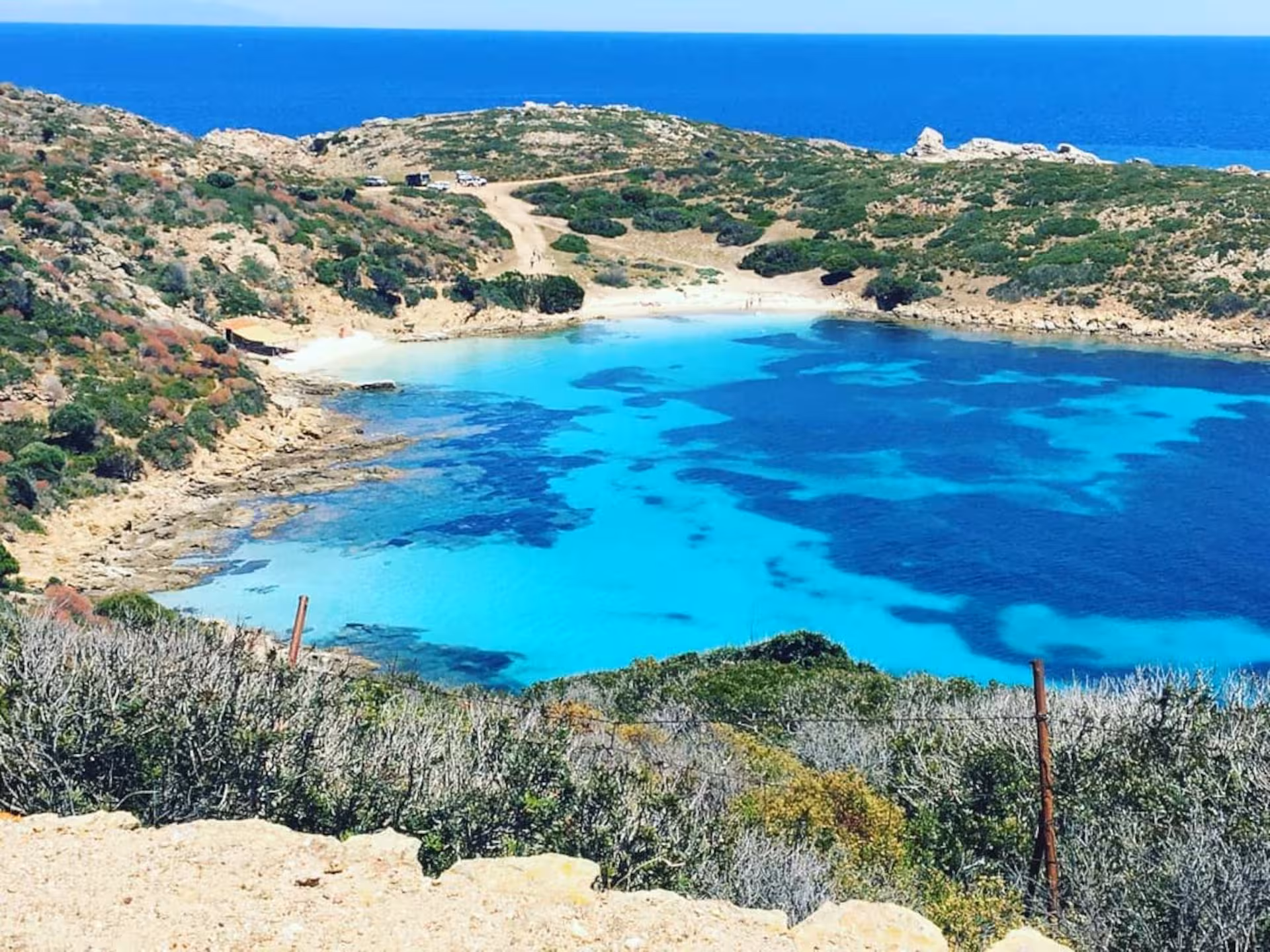 Turquoise waters and rugged coastline of Asinara Island, seen on a wooden boat tour from Stintino.