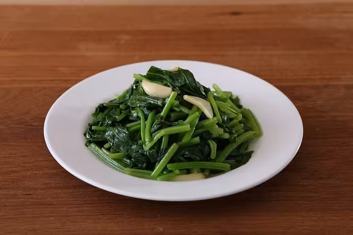 A plate of fresh stir-fried spinach with garlic served at Taipei Hungzhou Xiaolongbao, perfect for a healthy dining experience.