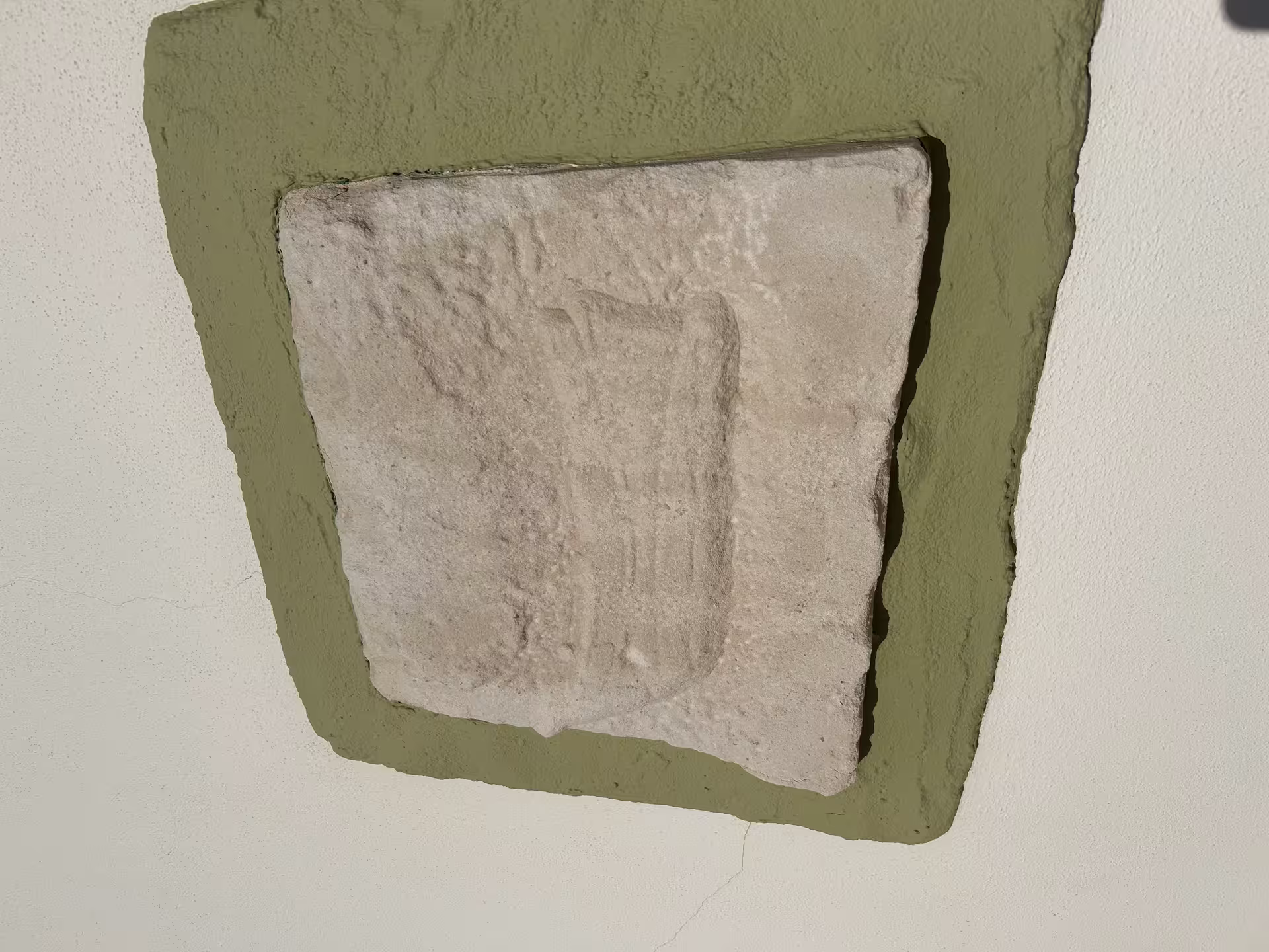 Ancient stone carved emblem embedded in a wall seen during the Seven Hanging Valleys guided tour Algarve