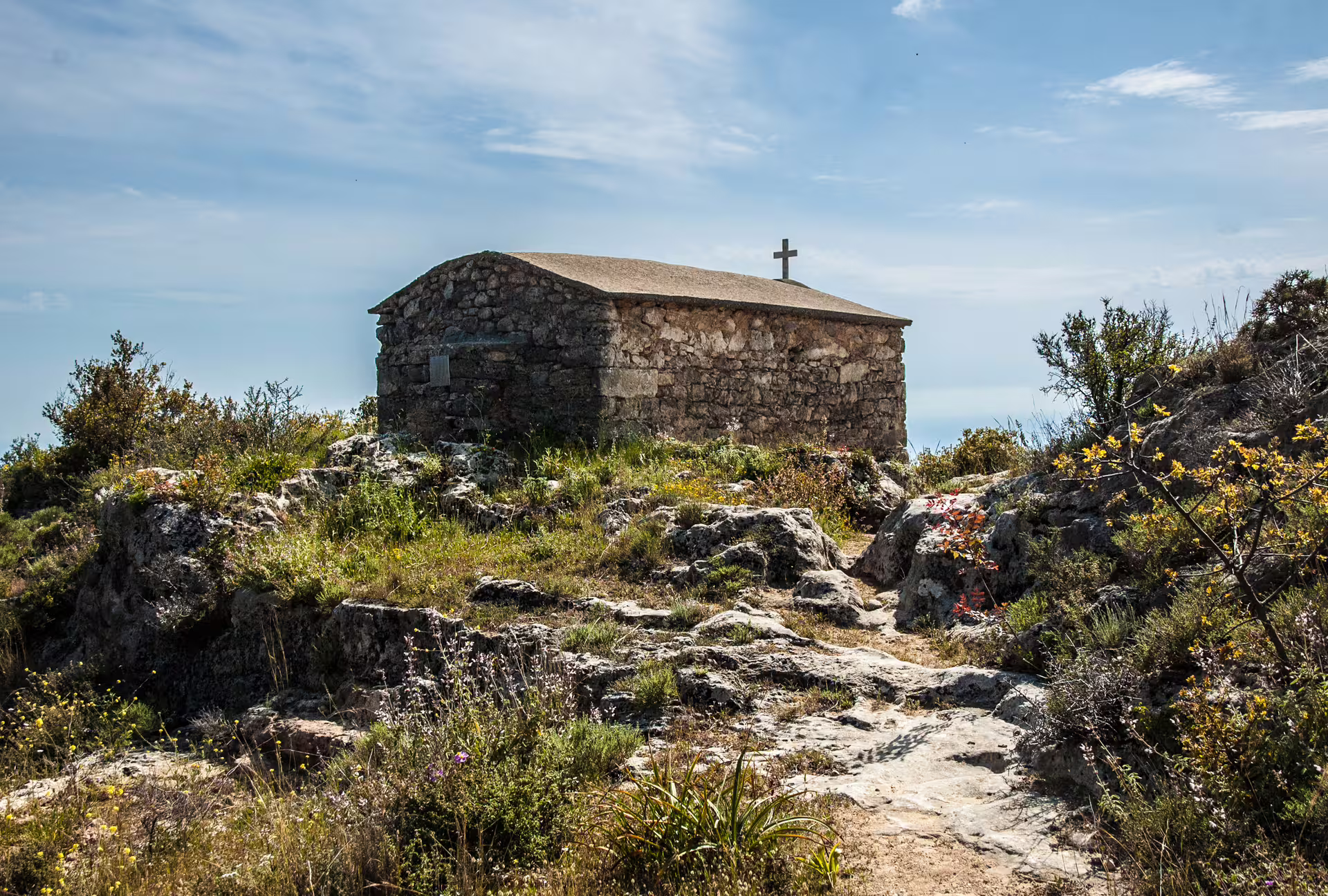 Stone hilltop chapel on rocky trail during Kardamyli hiking tour in Mani, Peloponnese, Greece