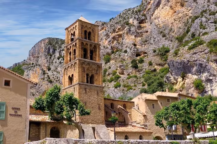 Historic stone tower nestled against rocky cliffs in a charming village in the Grand Canyon of Europe.