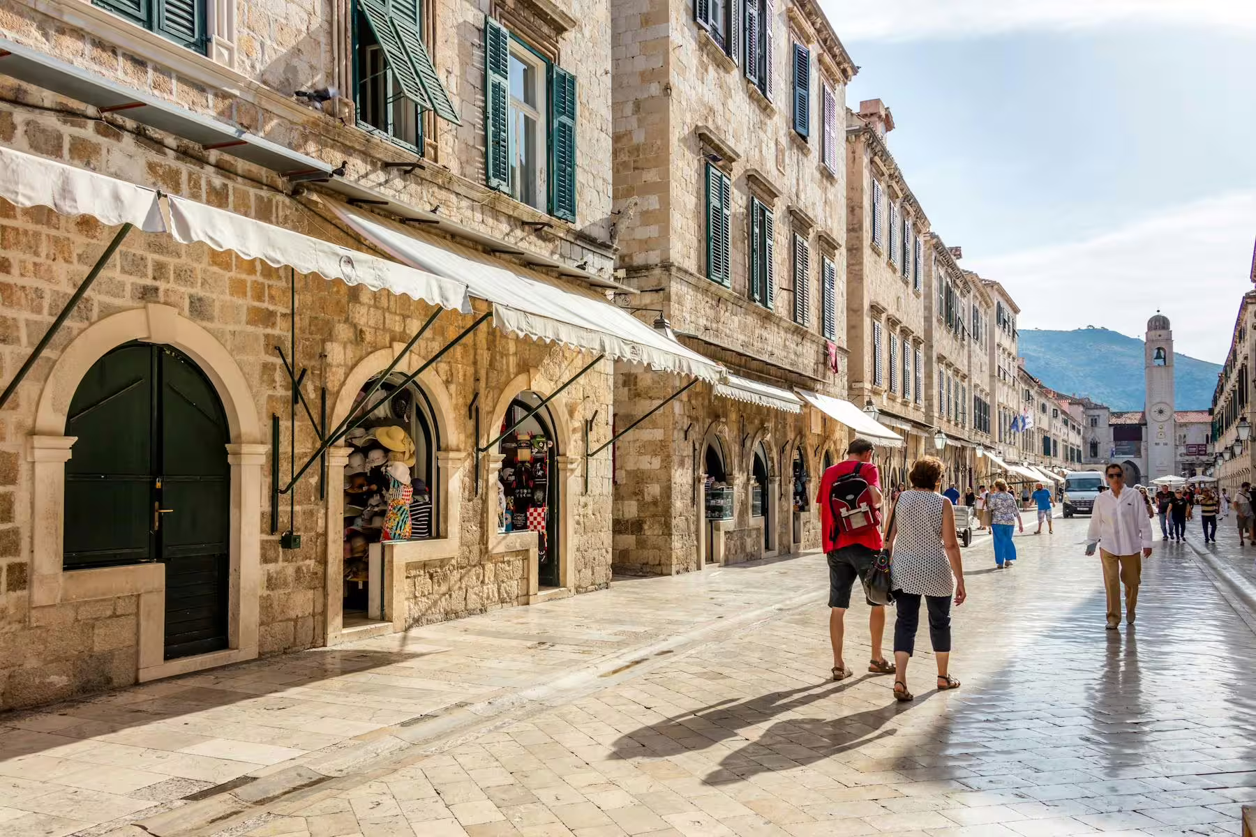 Stradun street in Dubrovnik Old Town with shops and travelers, walking tour highlight on day trip from Makarska Riviera